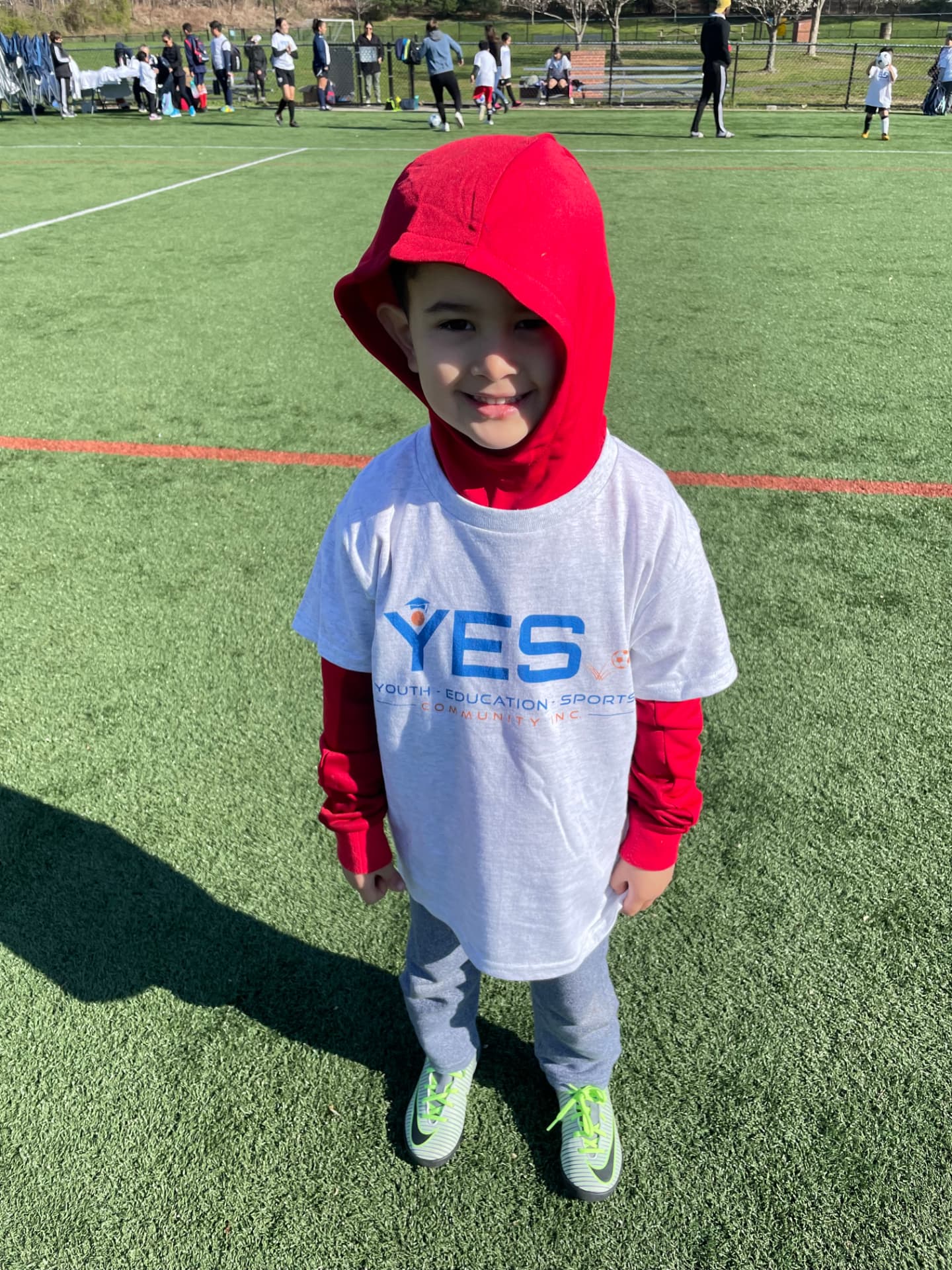 A young YES player in a white YES t-shirt on the turf